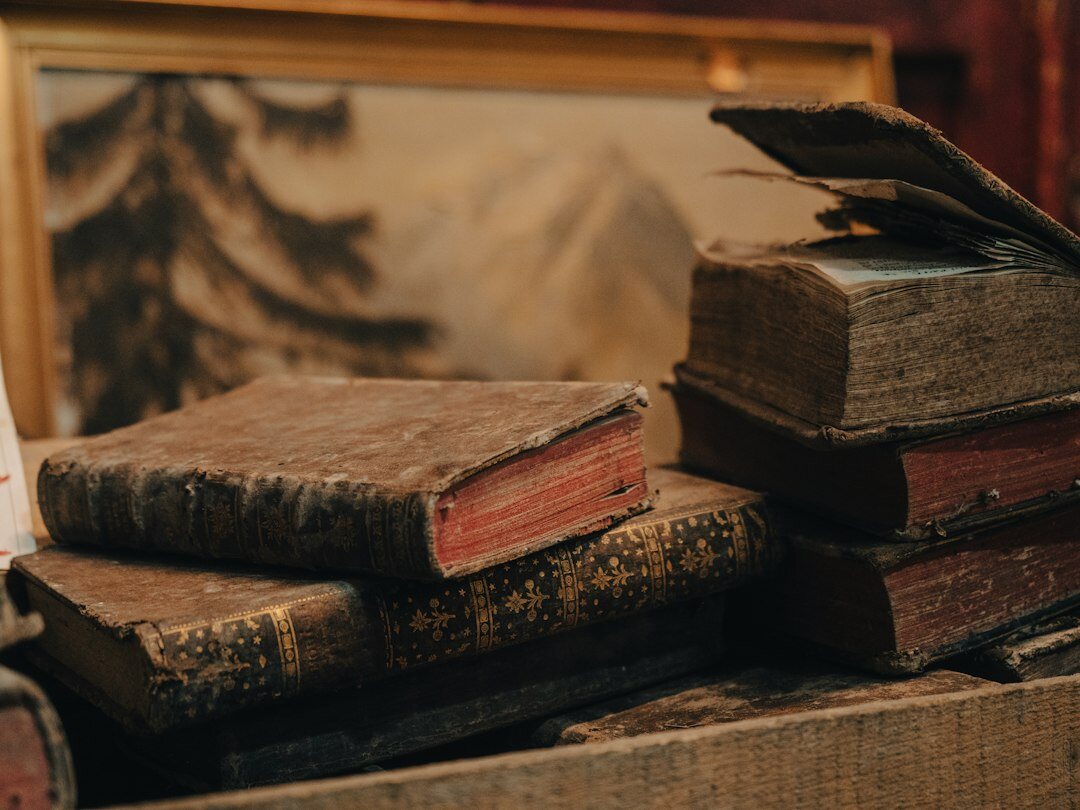 Stack of old mystery novels with a magnifying glass